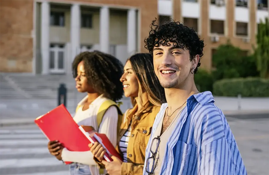 couple of young people smiling in front of university